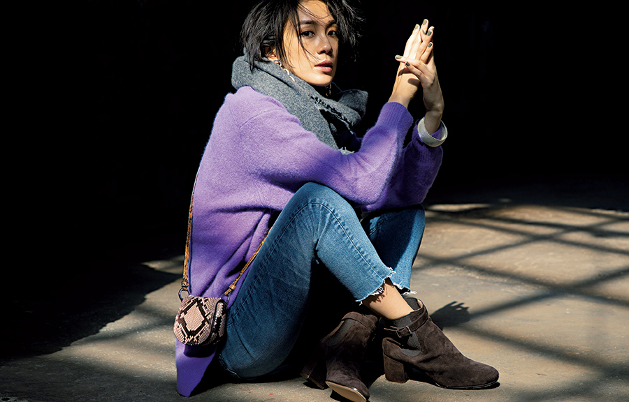 紫のニットにデニムパンツをあわせたモデル写真