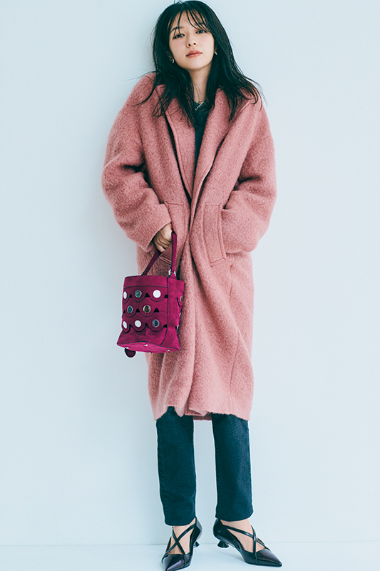 暗いグレーのスエットとデニムにくすんだピンクのロングコートをはおったモデル写真