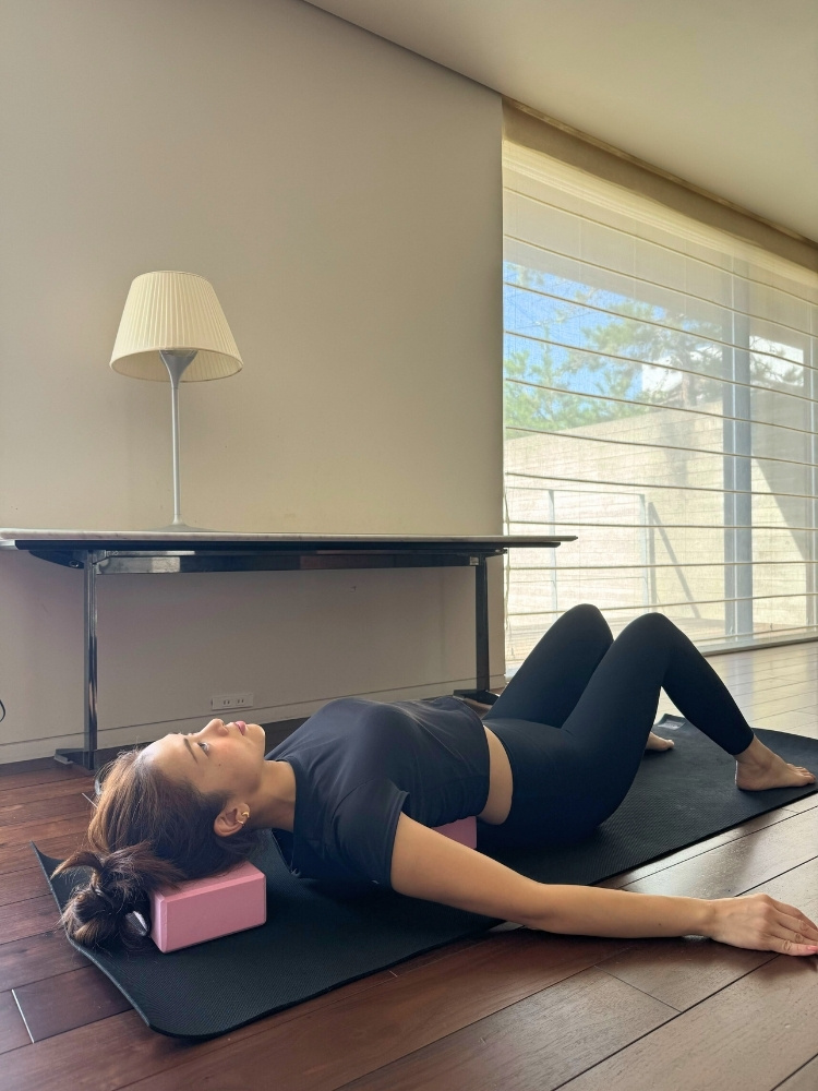 ブロックの上に寝転がって膝を立てている写真