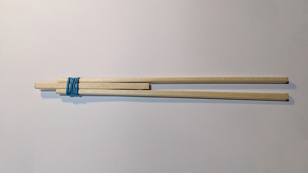 割った割り箸の間に半分に切った割り箸を輪ゴムでとめた写真