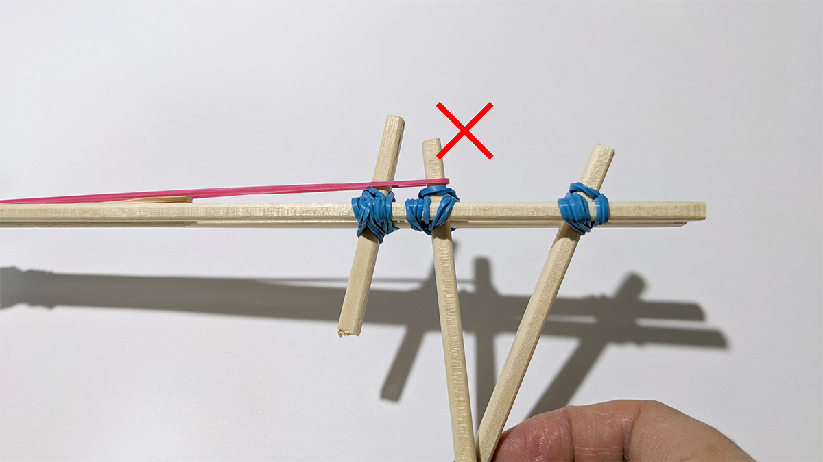 割りばし鉄砲を持った手元の写真 誤ってグリップ部分に輪ゴムがかかっている