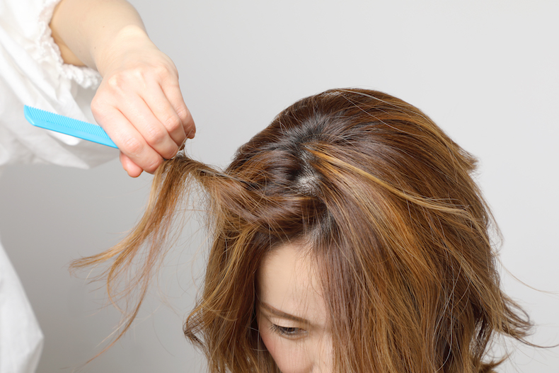 コームで髪を分けとっている写真