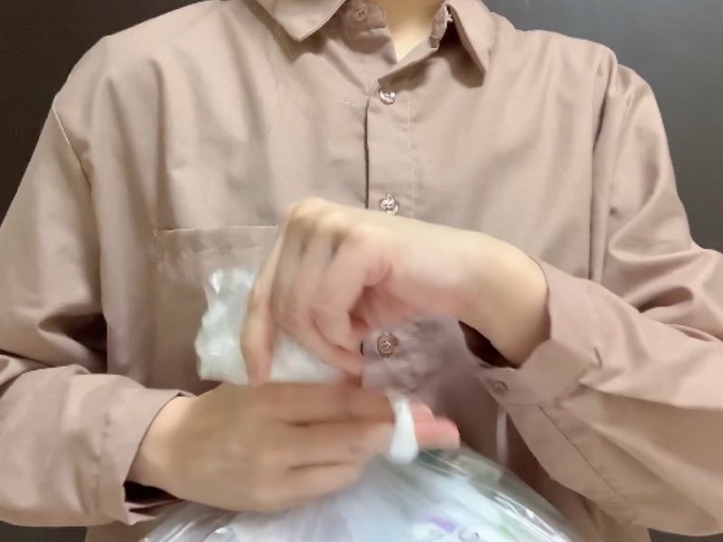 ねじったゴミ袋の上部を輪にする様子