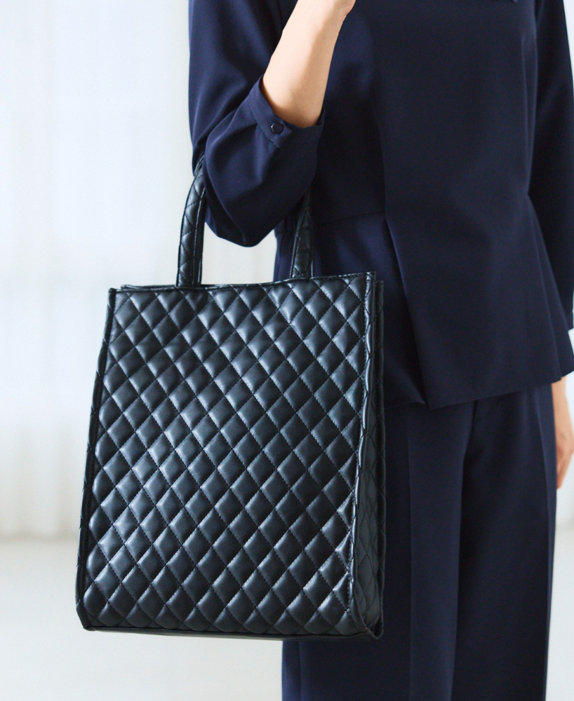 キルティングトートバッグを持った人