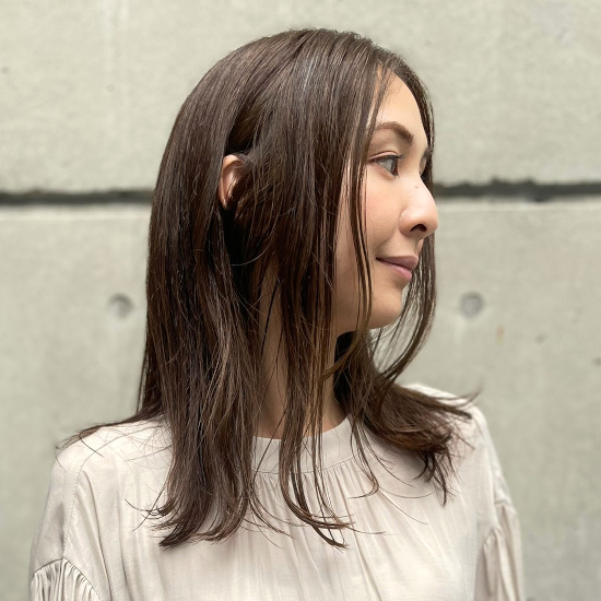 毛先がほのかにワンカールしたセミロングヘアの写真 横顔
