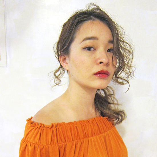 強めのウェーブがかかった前髪なしポニーテールの正面写真