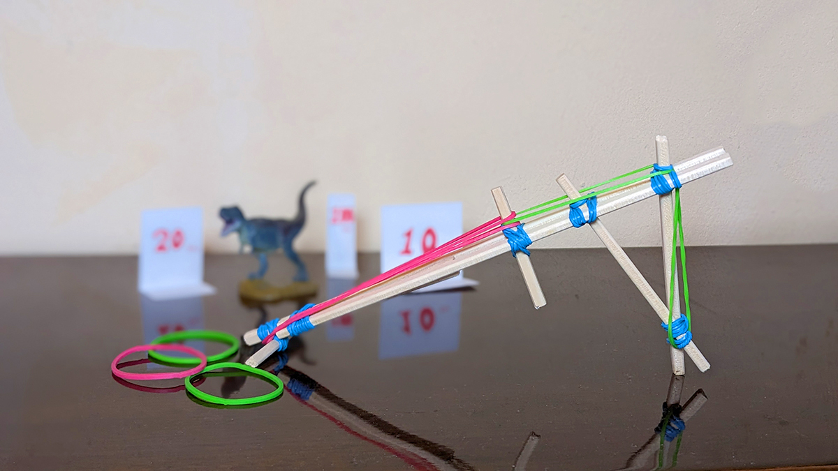 ピンクや緑の輪ゴムがついた割りばし鉄砲の写真