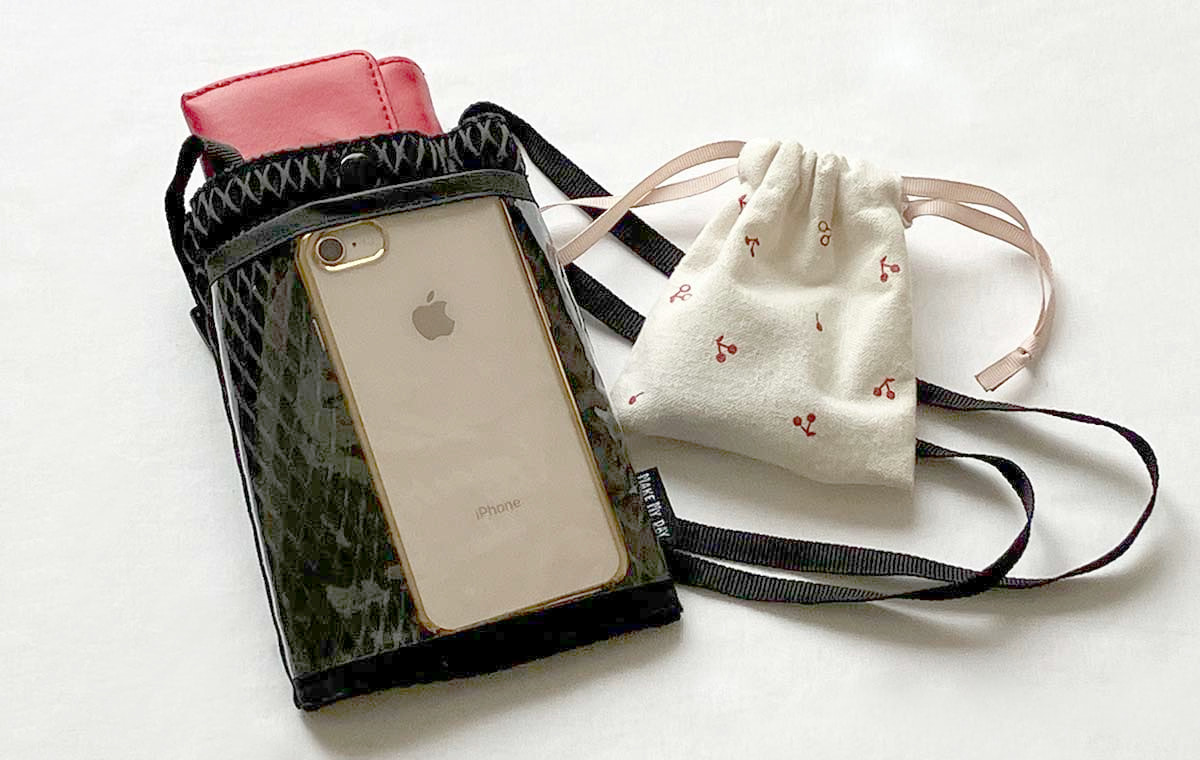 前ポケットに入ったスマホと大きいポケットに入ったミニ財布、巾着の写真