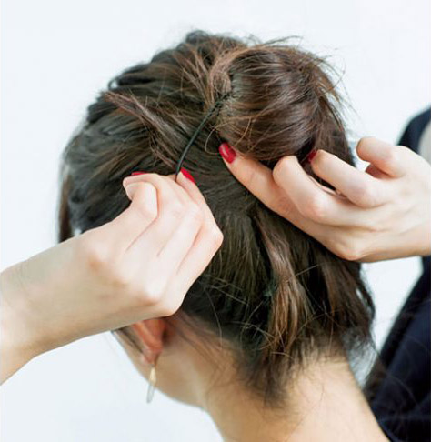 毛先をゴムに挟んでいる後頭部写真