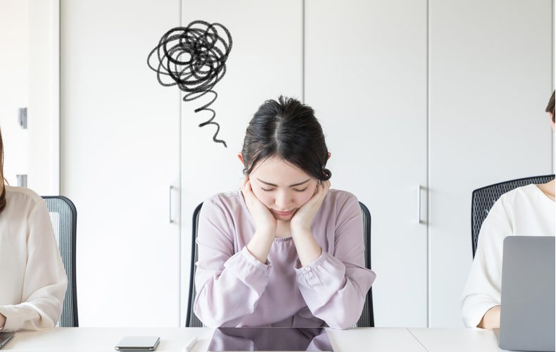 オフィスで悩む女性の写真