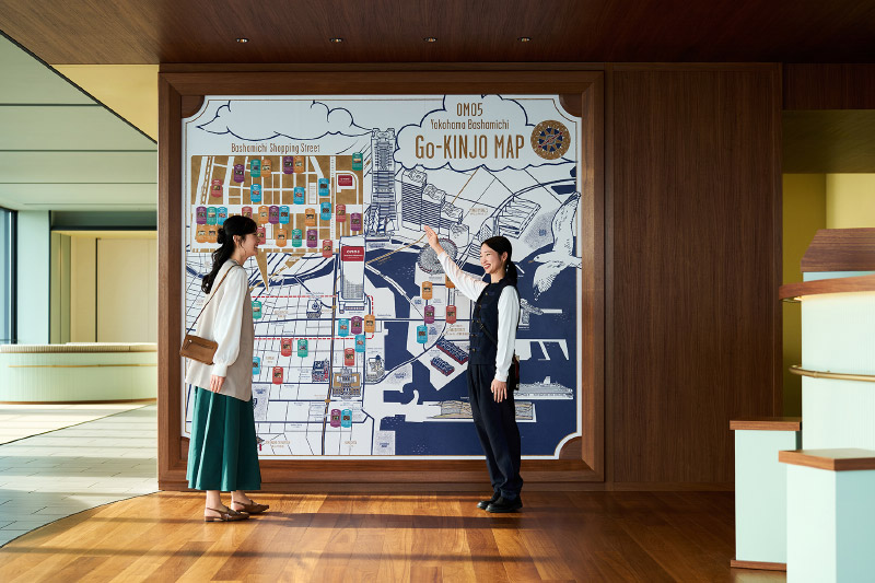 OMO5横浜馬車道　周辺マップの前に立つ2人の女性
