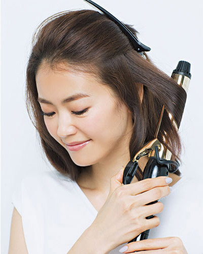 表面の髪をクリップで留め、サイドの髪を巻いている写真