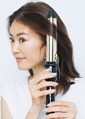 クリップを外し、表面の髪を後ろに向かって巻いている写真