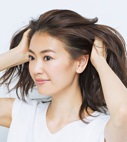 手で髪をほぐしている写真