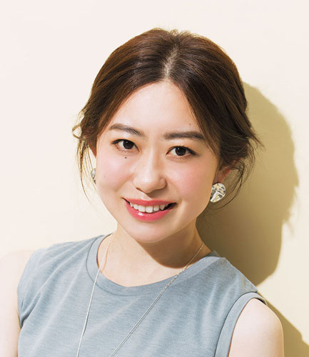 真ん中分けで髪を後ろにまとめたヘアアレンジの正面写真