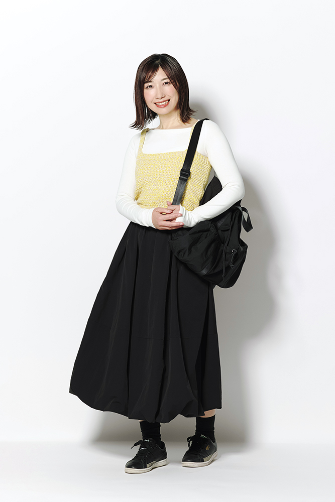白カットソー×黄色ニットキャミ×黒フレアスカート×黒リュック×黒スニーカーのカジュアルコーデ