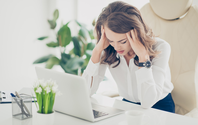 PCの前で頭を抱える女性