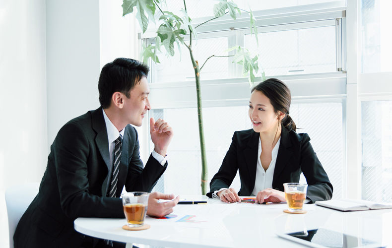 打ち合わせをするスーツ姿の男女