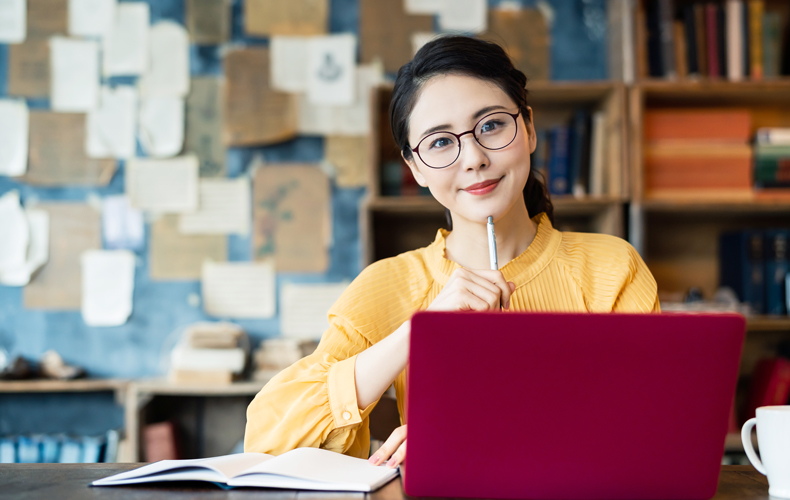 PCの前で考える女性の写真