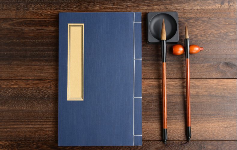 古い本と筆の写真