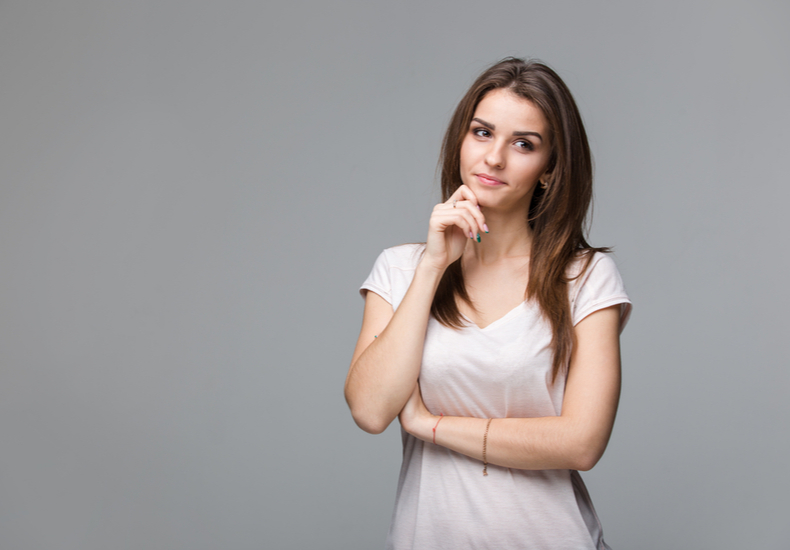 顎に手を当てて首を傾げる人の写真