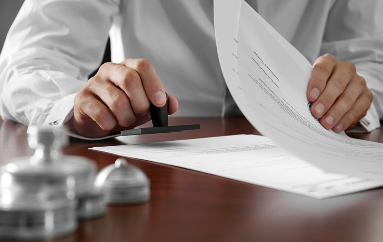 書類にハンコを押す手元の写真