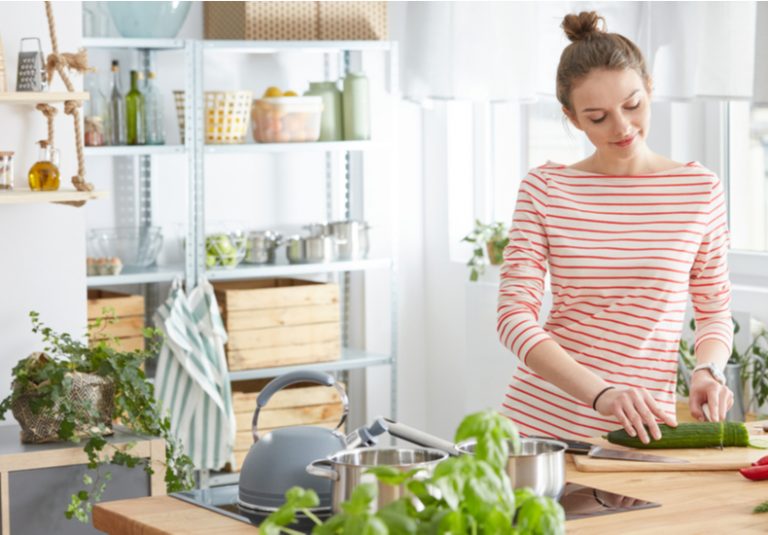 キッチンで野菜を切る人の写真