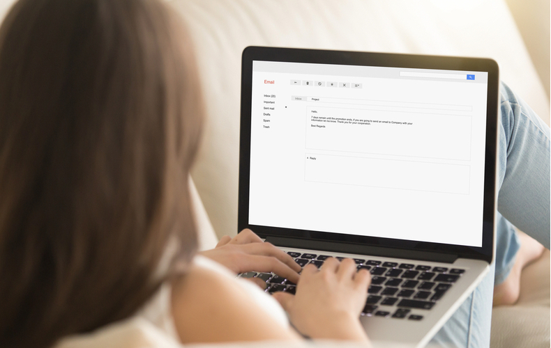 ノートパソコンでメールをしている女性の写真