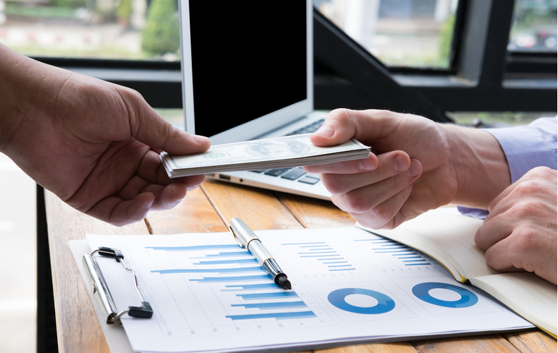 デスクでお金を受け取る人の写真