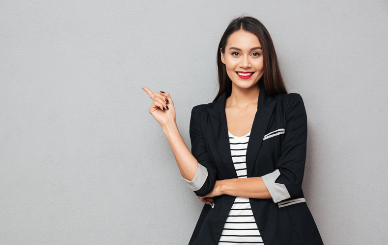 人差し指を立てて笑顔の女性