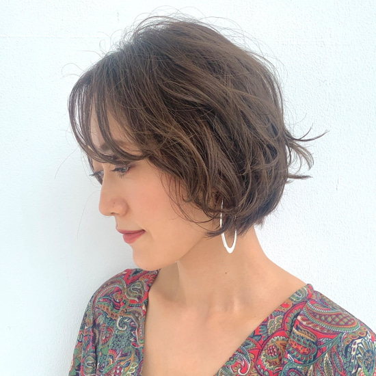 前髪ありでゆるいパーマをかけたショートボブヘアのモデル写真　横顔