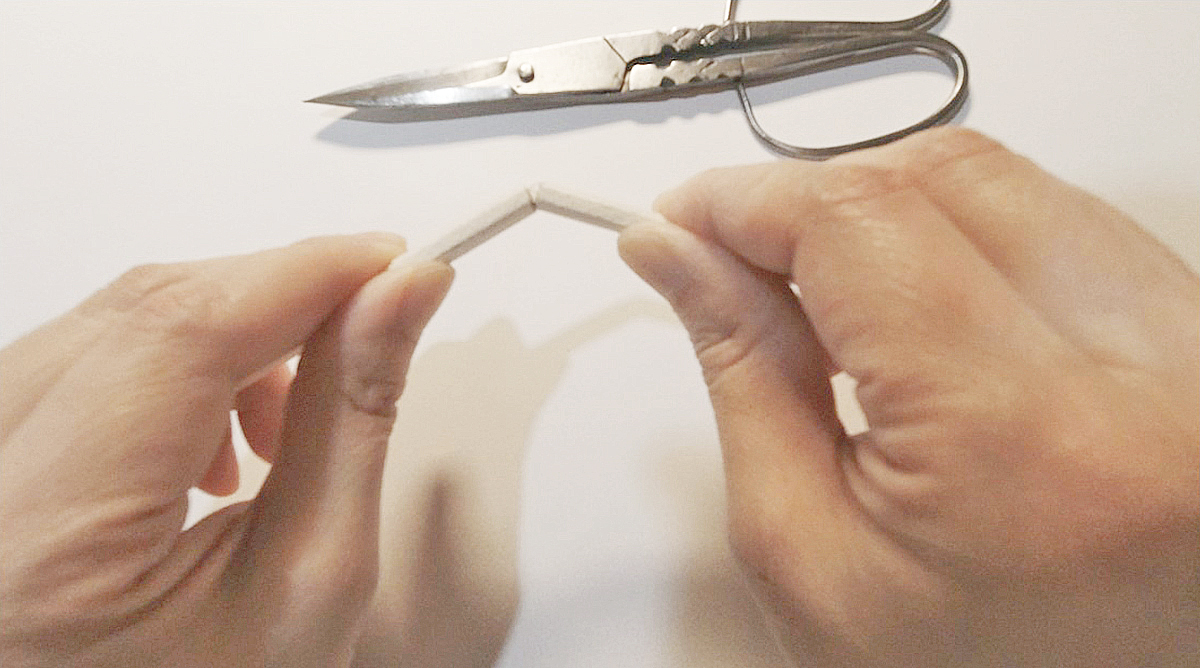 手で割り箸を半分に折っている写真