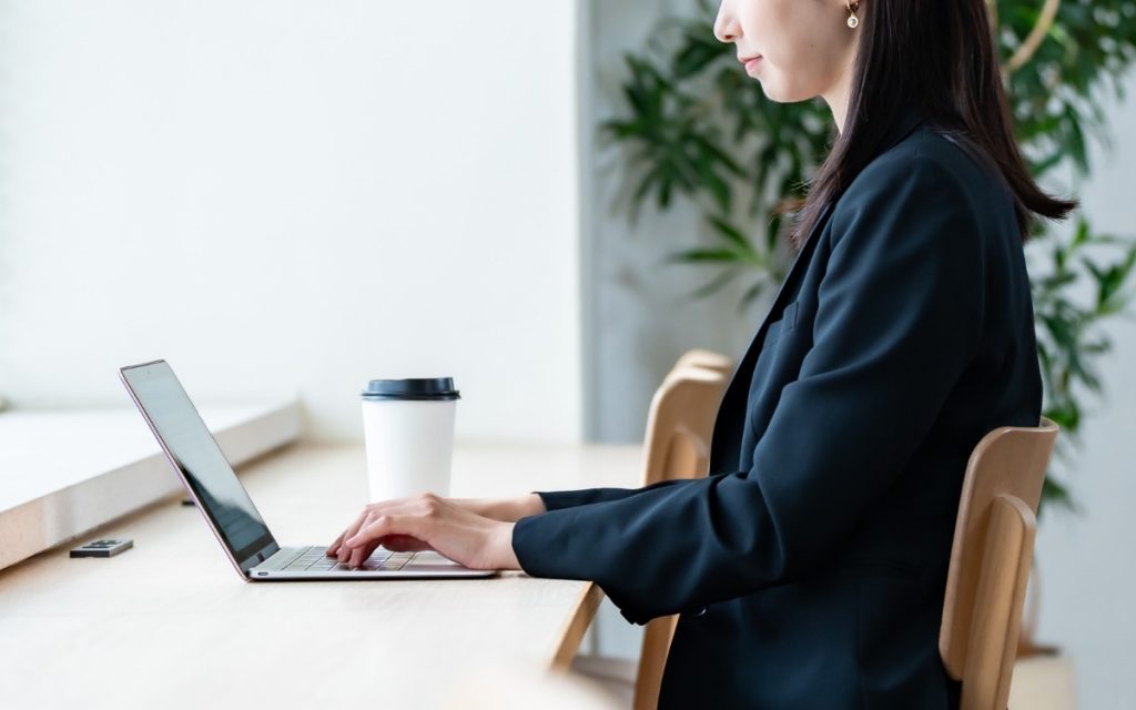 ノートPCを操作するビジネスウーマンの写真