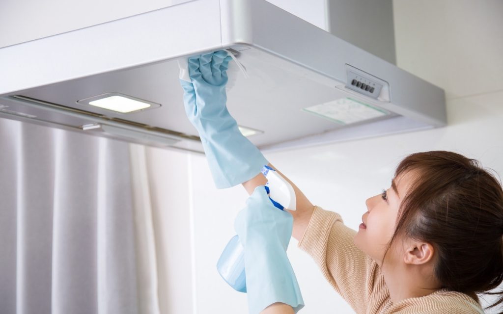 キッチンフードを掃除する女性の写真