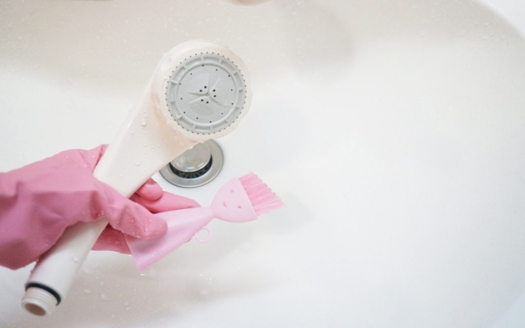 分解したシャワーヘッドを掃除している写真