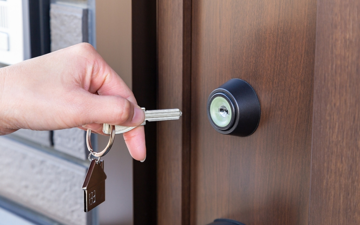玄関ドアにカギをさそうとしている手元の写真