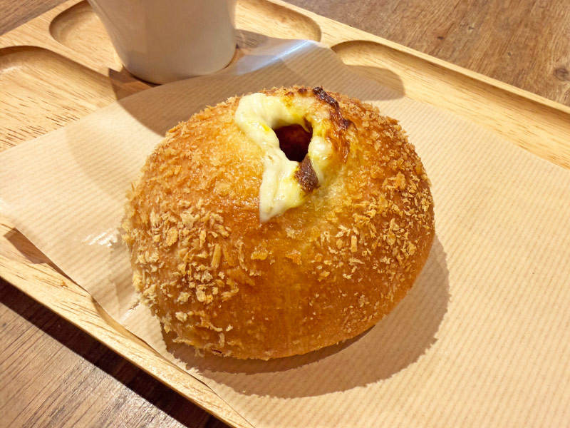 木のトレーにのっているカレーパンの写真