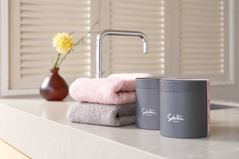 キッチンに置かれた2色のタオルと筒形の箱