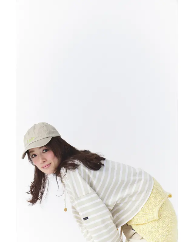 ベージュキャップ×ライトベージュ地に白ボーダーのカットソー×腰巻イエローニット×ライトベージュパンツ×黒パンプスコーデ