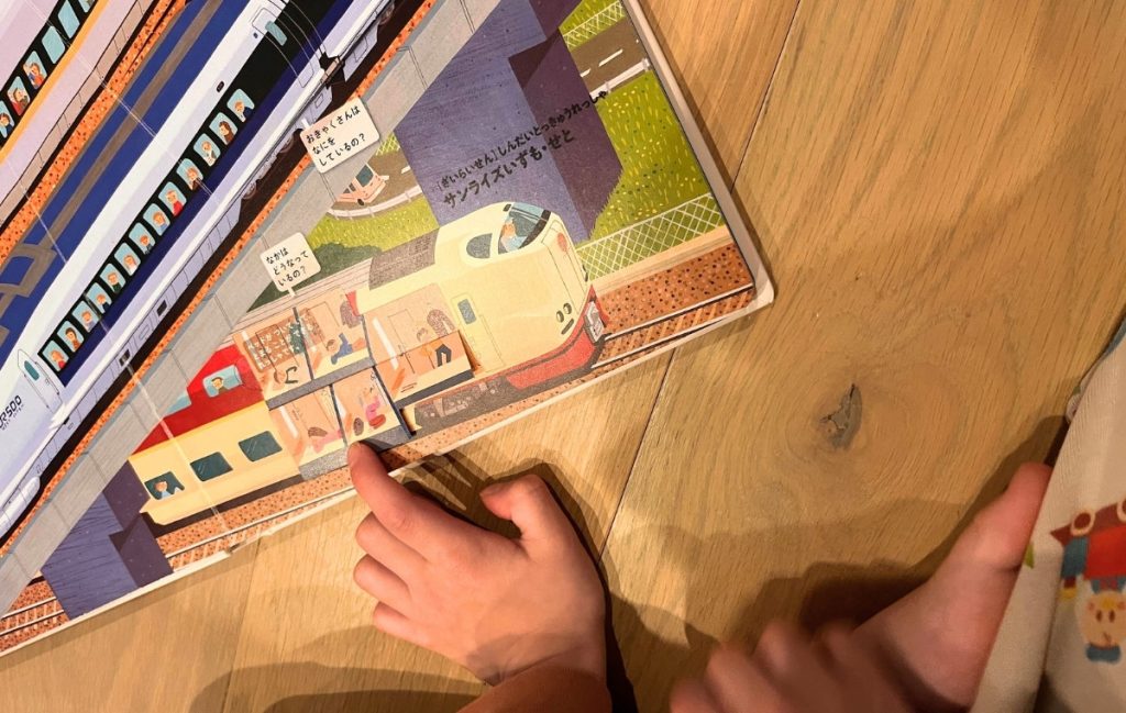 サンライズが描かれた絵本を指さす息子さんの写真