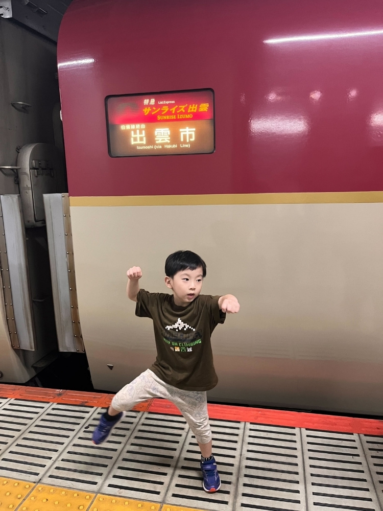 電車のドアの前でポーズをとっている息子さんの写真