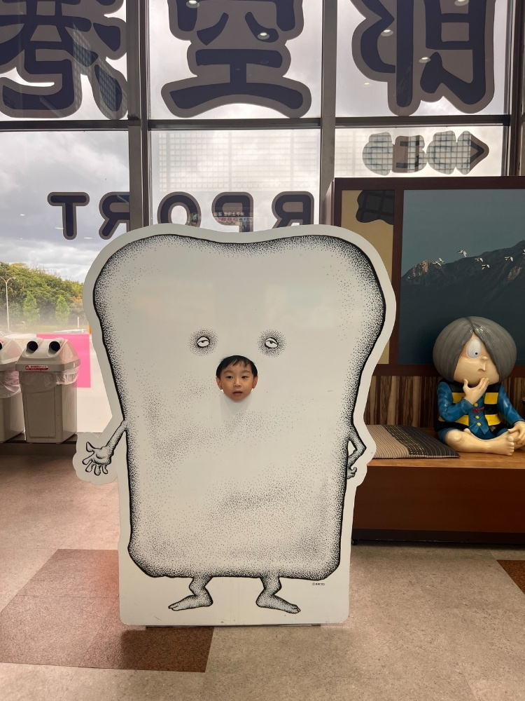 塗り壁の顔はめパネルに顔を入れている息子さんの写真