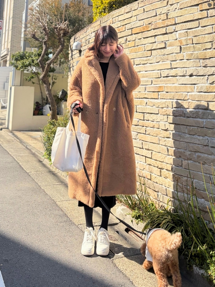 テディベアコートを着て犬の散歩をしている飯島さんの写真