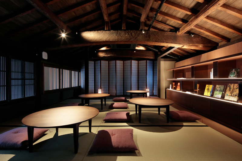 町家の中に丸テーブルと座布団を置いた写真