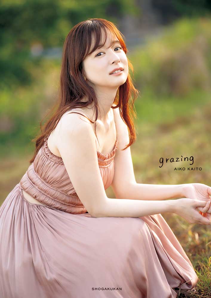皆藤愛子 写真集『grazing』表紙書影。草原をバックにピンクのワンピースをまとった皆藤愛子さん