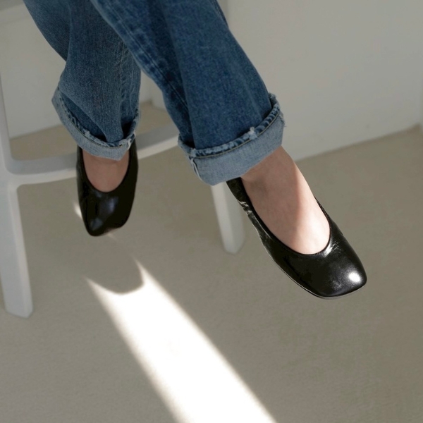 デニムに黒のバレエシューズを履いた女性の足元の写真