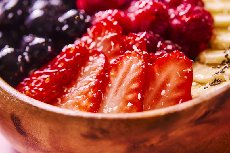 いちご、ブルーベリー、ラズベリー、バナナがのったボウル　いちごの寄り写真