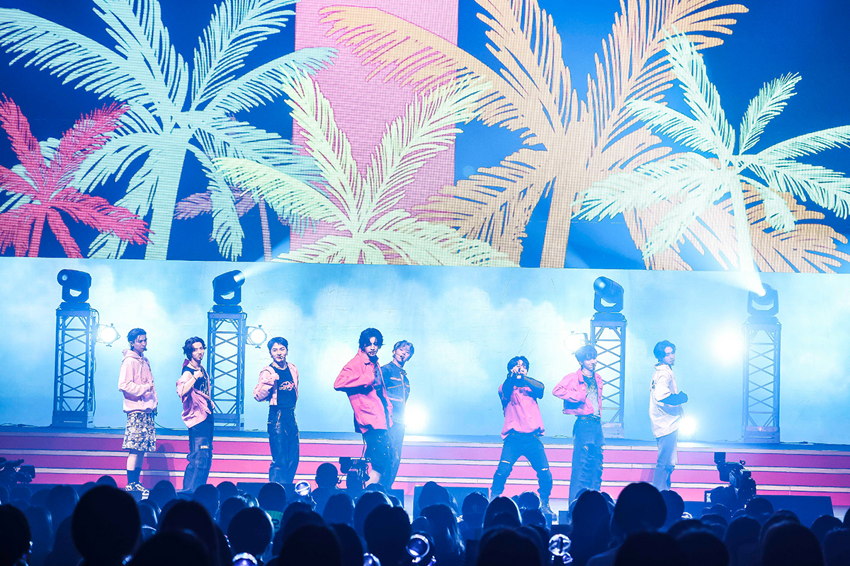 椰子の木の映像を背景に踊るPENTAGONメンバー