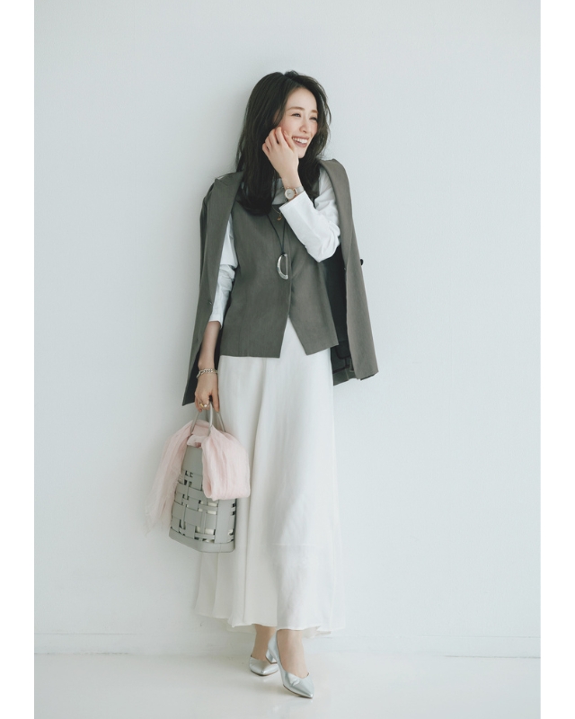 肩掛けしたグレージャケット×グレーのジレ×白カットソー×白スカート×シルバーパンプスコーデ
