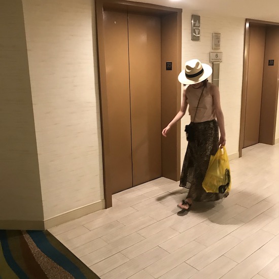 エレベーターホール前を歩いている人の写真